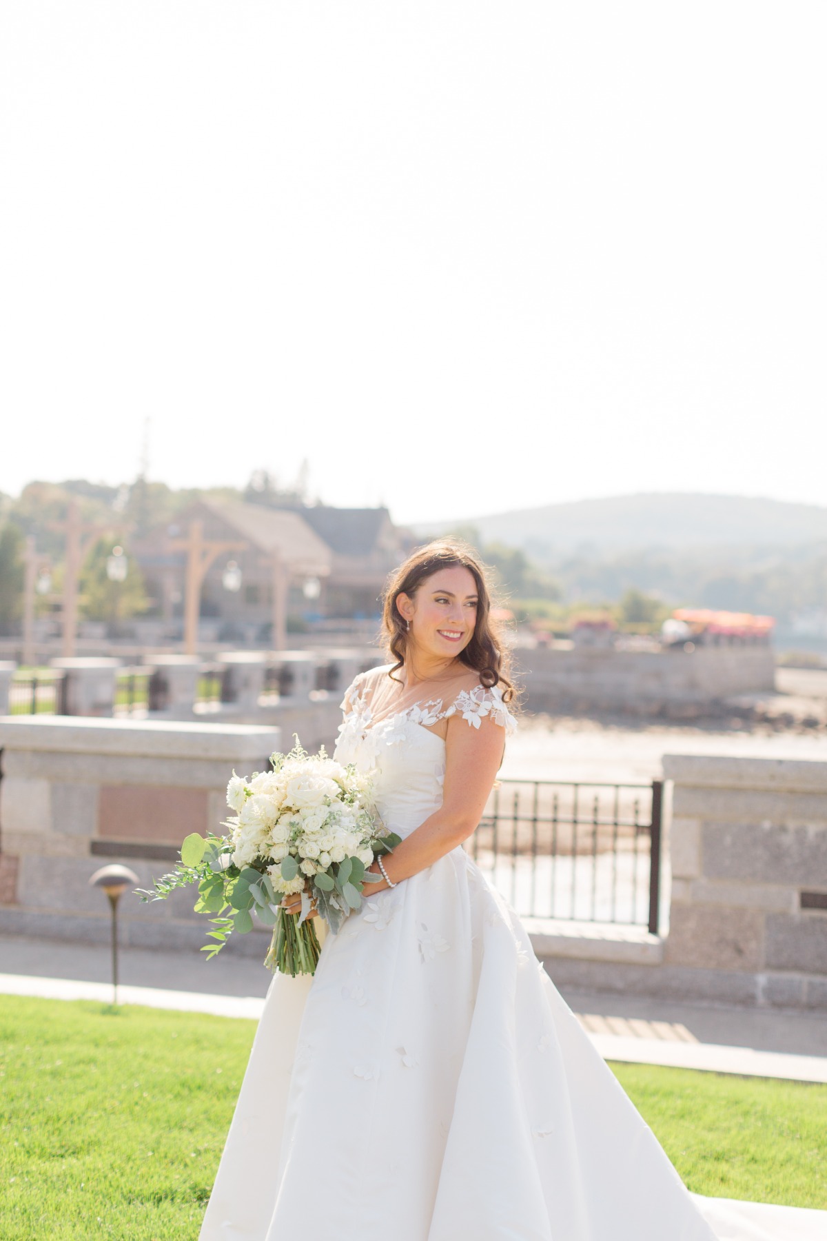 bride poses by maine coastline