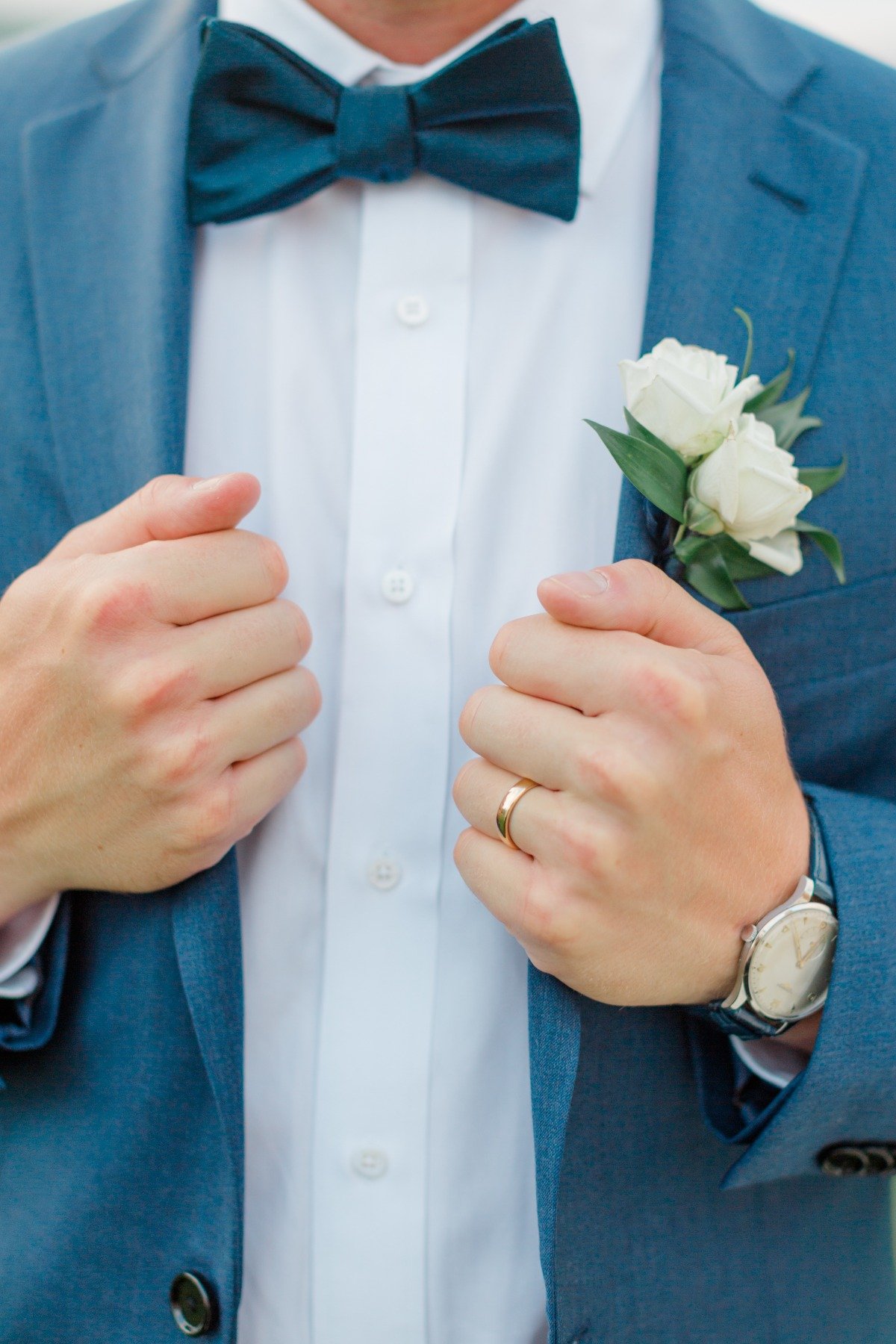 groom in blue tux with white rose boutonnière 