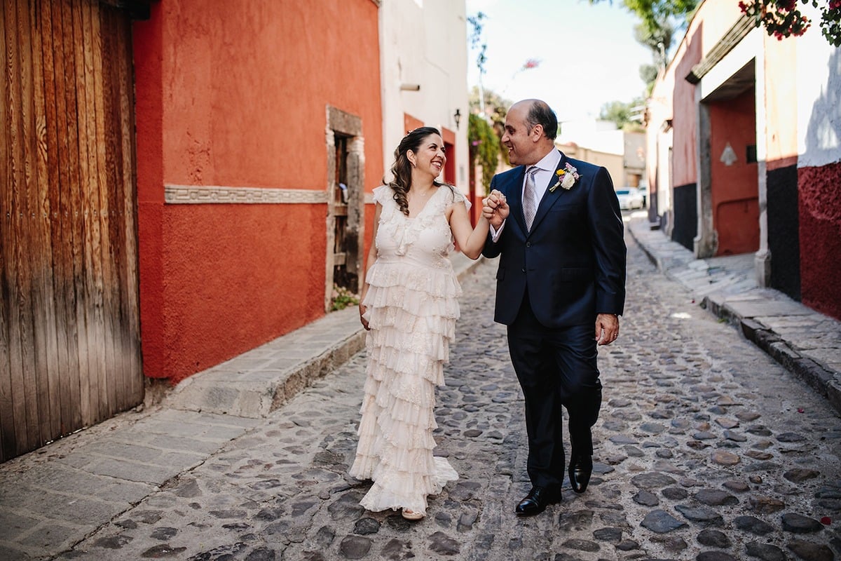 bride and groom walking through old town san miguel mexico