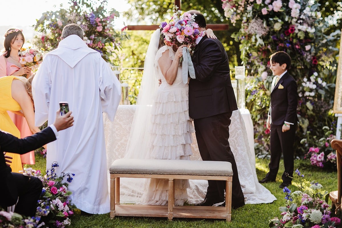 bride and groom kiss at garden wedding ceremony