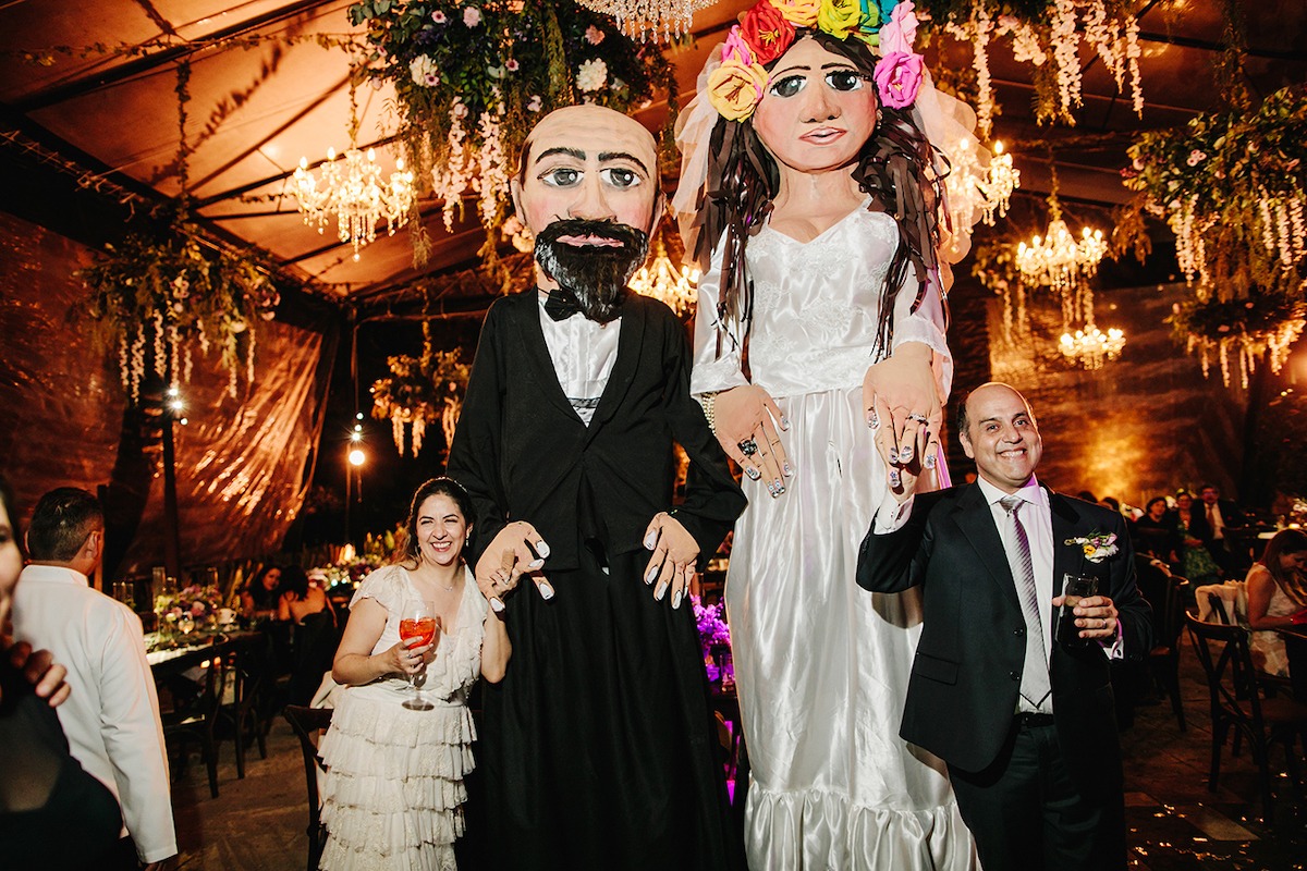 bride and groom with mexican puppets for wedding parade