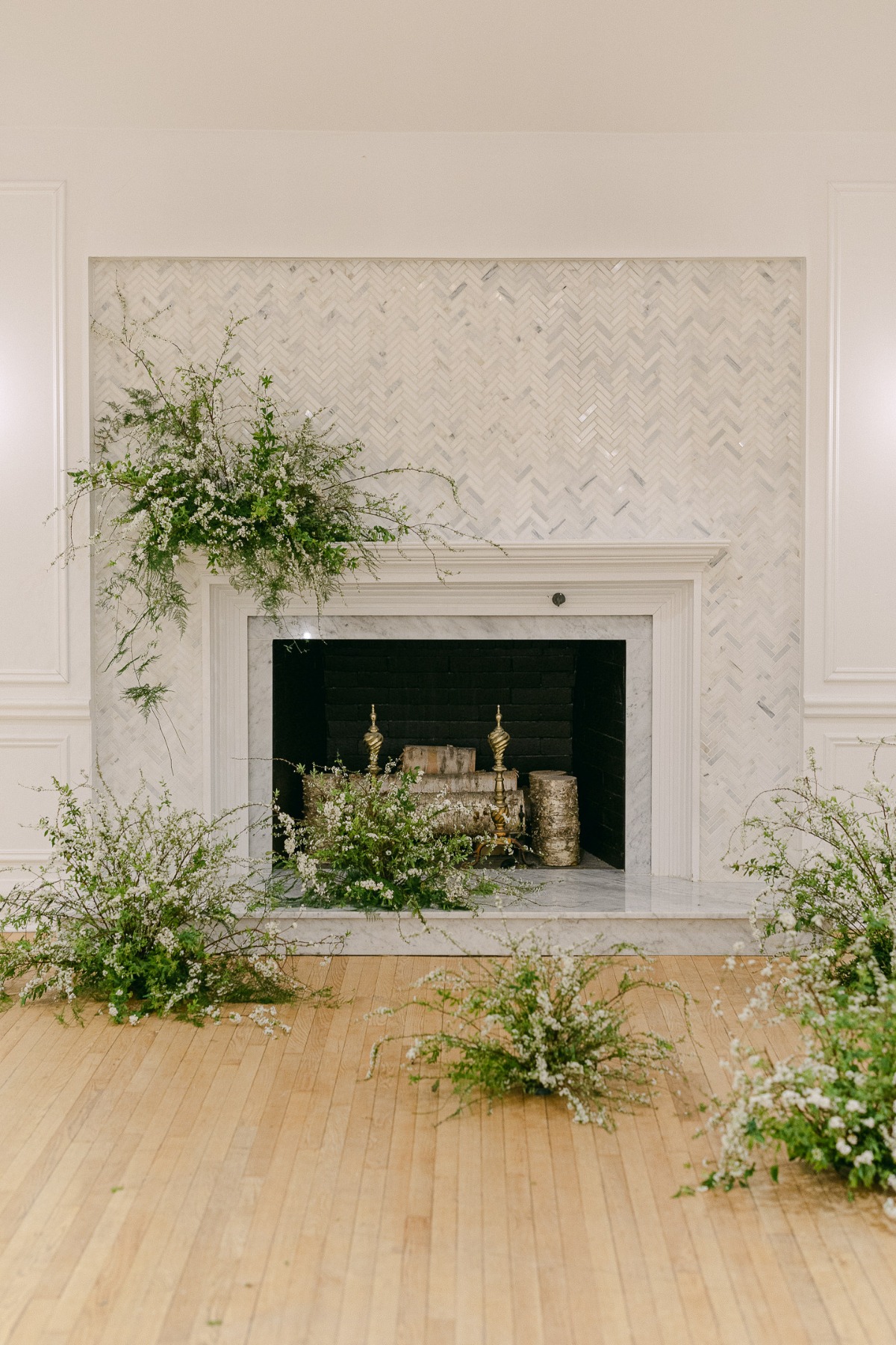 marble fireplace wedding ceremony with white and green arrangements