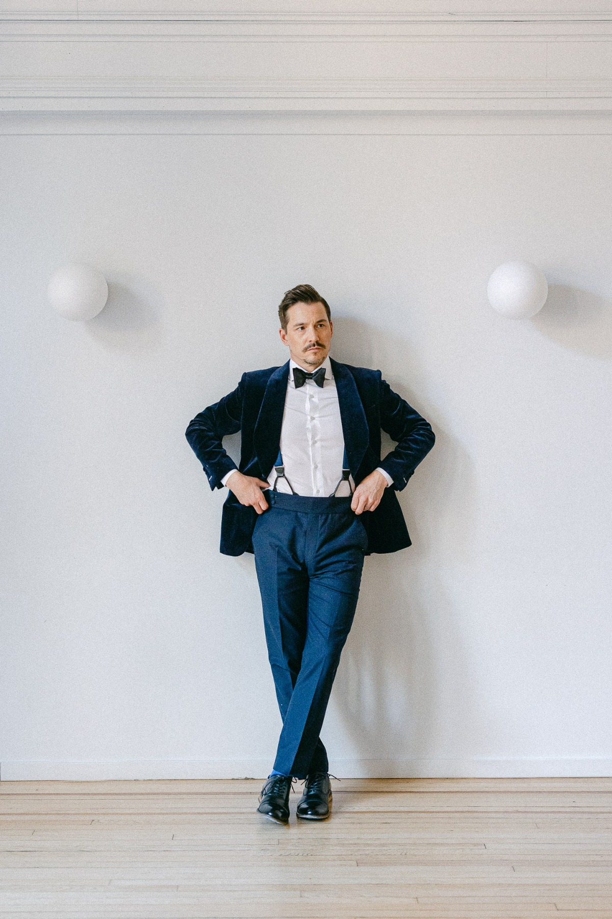 navy blue suit with suspenders and bow tie