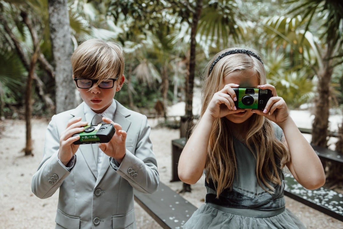 Wedding guest kids taking photos on film cameras 