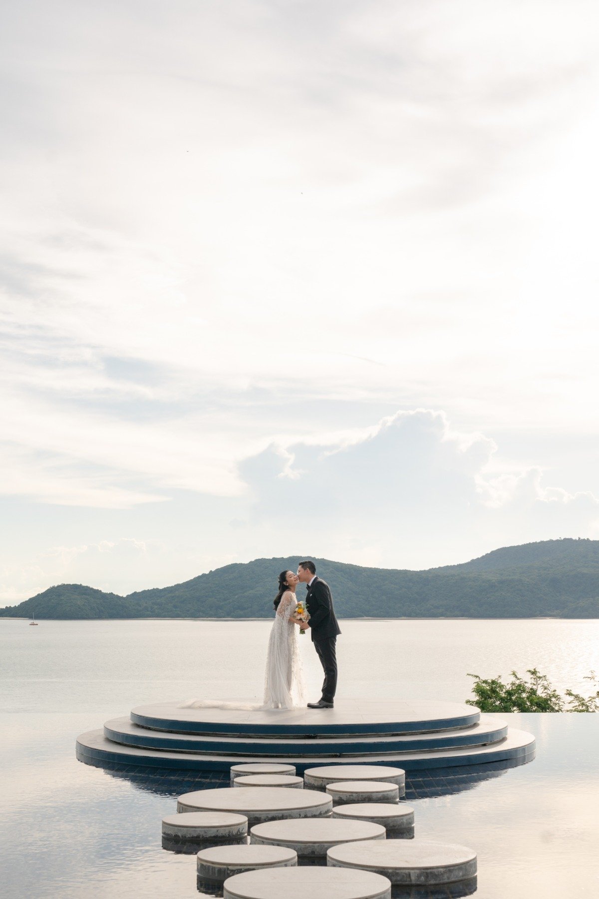 bride and groom with unique aisle on water with mountains