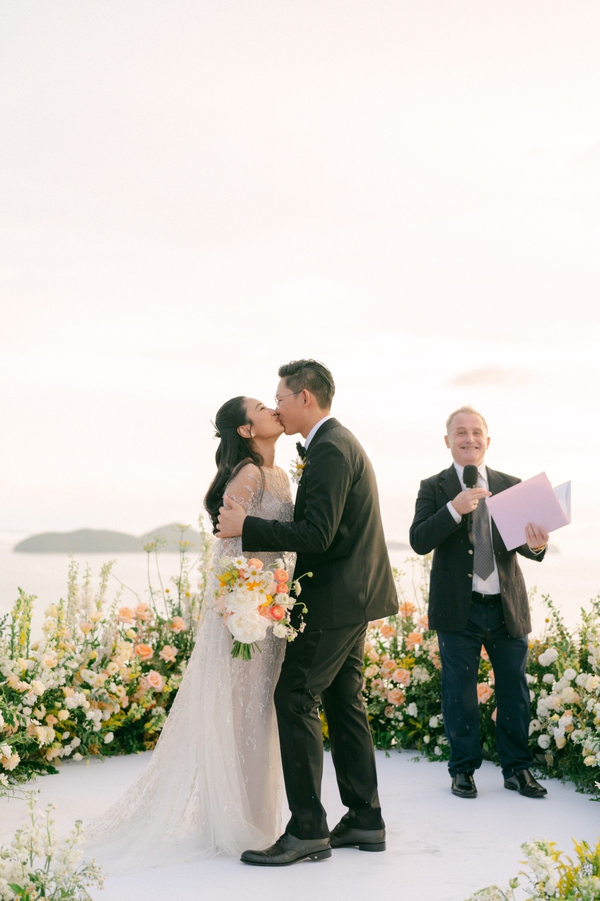 peach white and yellow wedding ceremony on the water