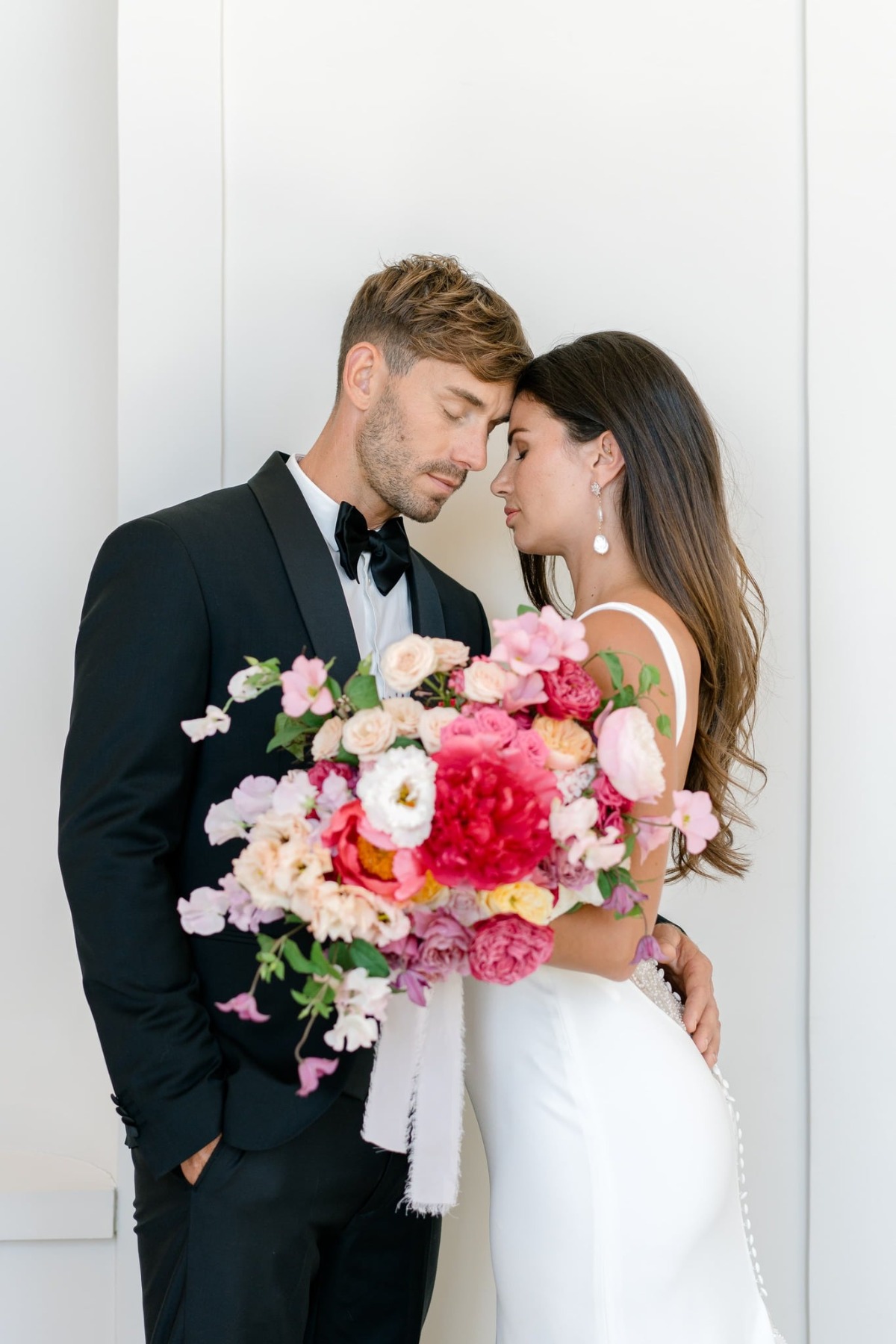 groom in black tux and bride in white mermaid gown