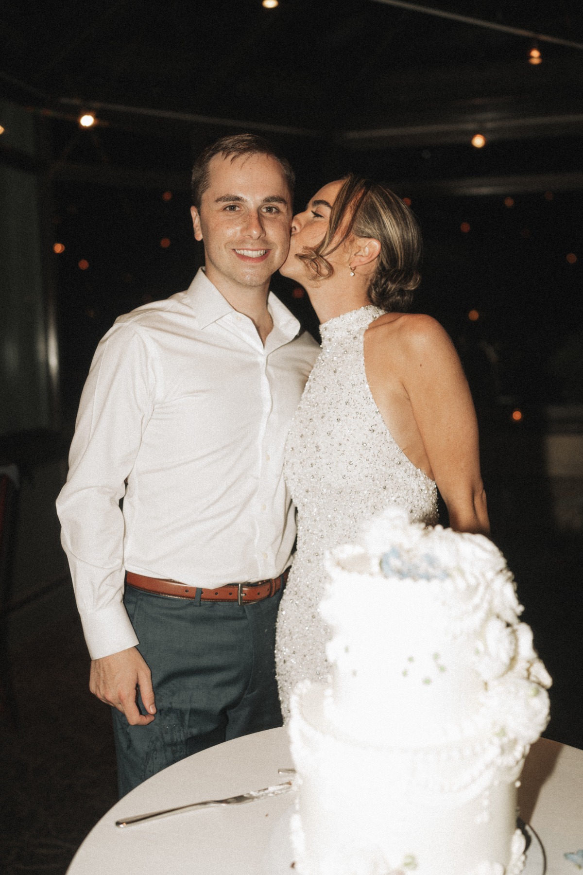 bride and groom with white wedding cake 