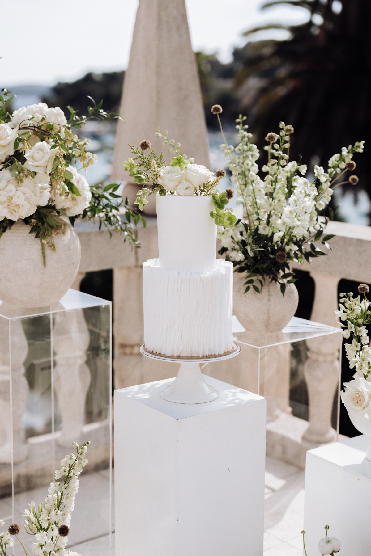 modern white wedding cake with fresh flowers