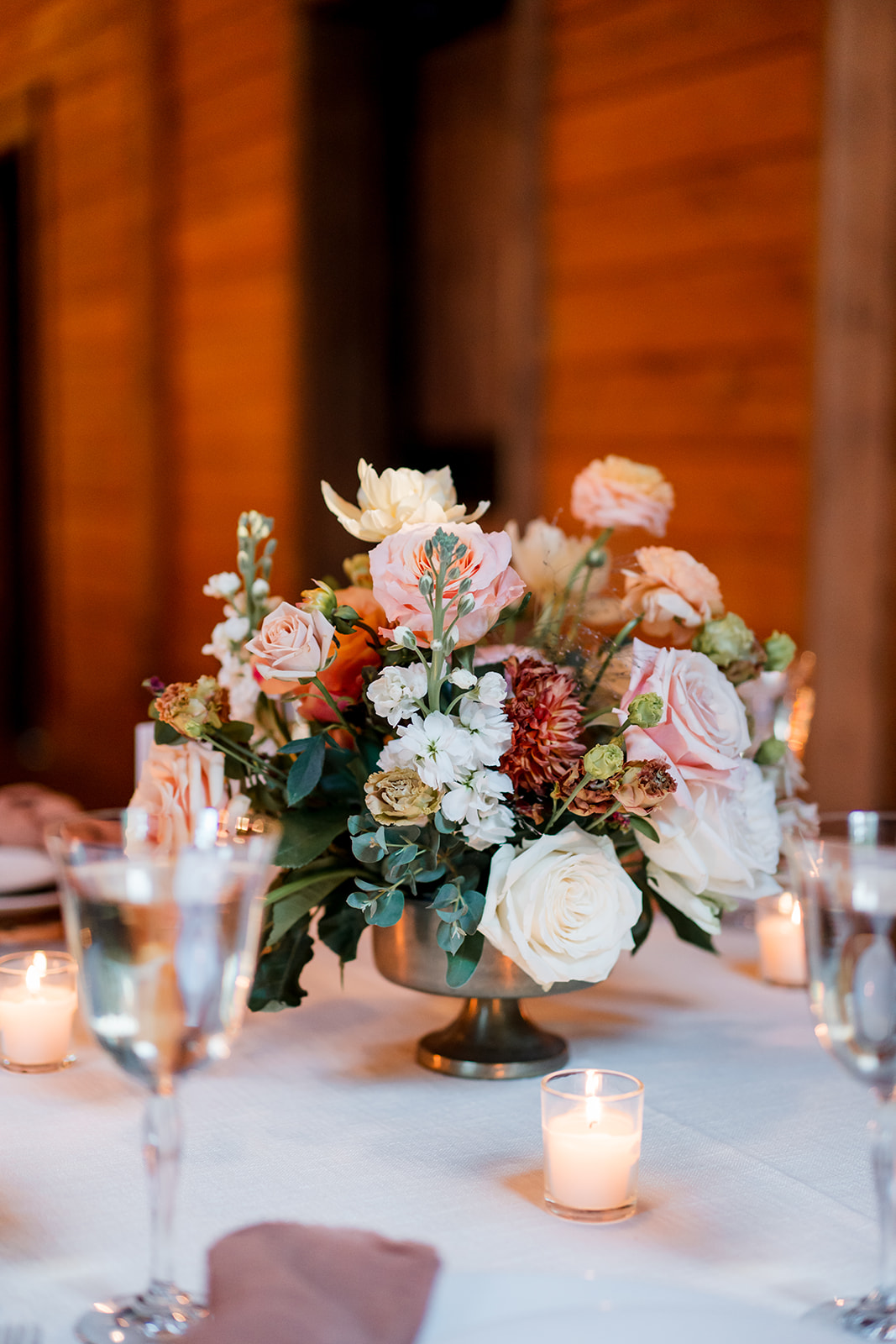 peach and blush wedding floral arrangements with candles