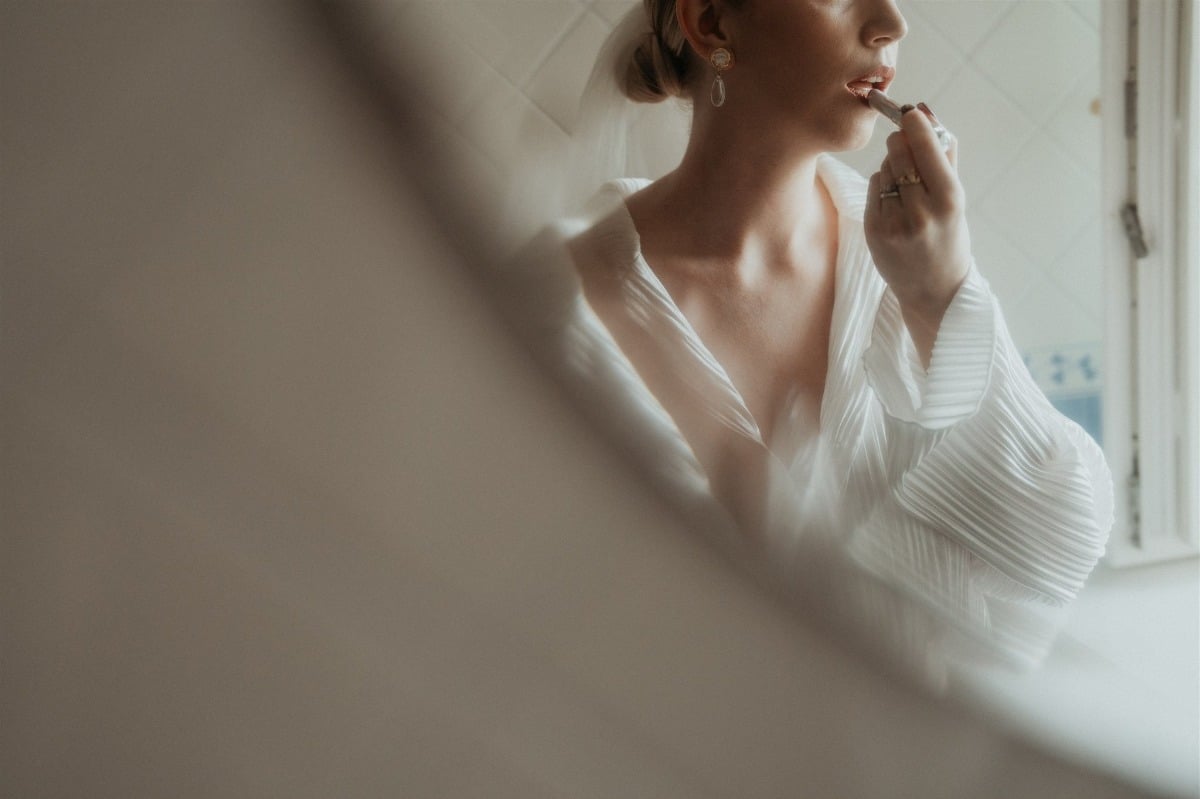 bride getting ready in white pleated pajamas