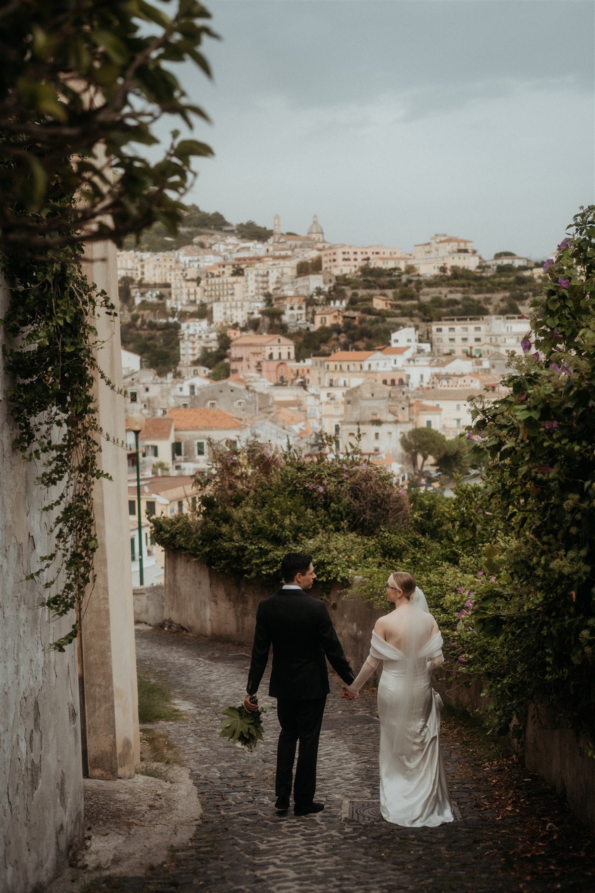 bride and groom walking through the streets of positano