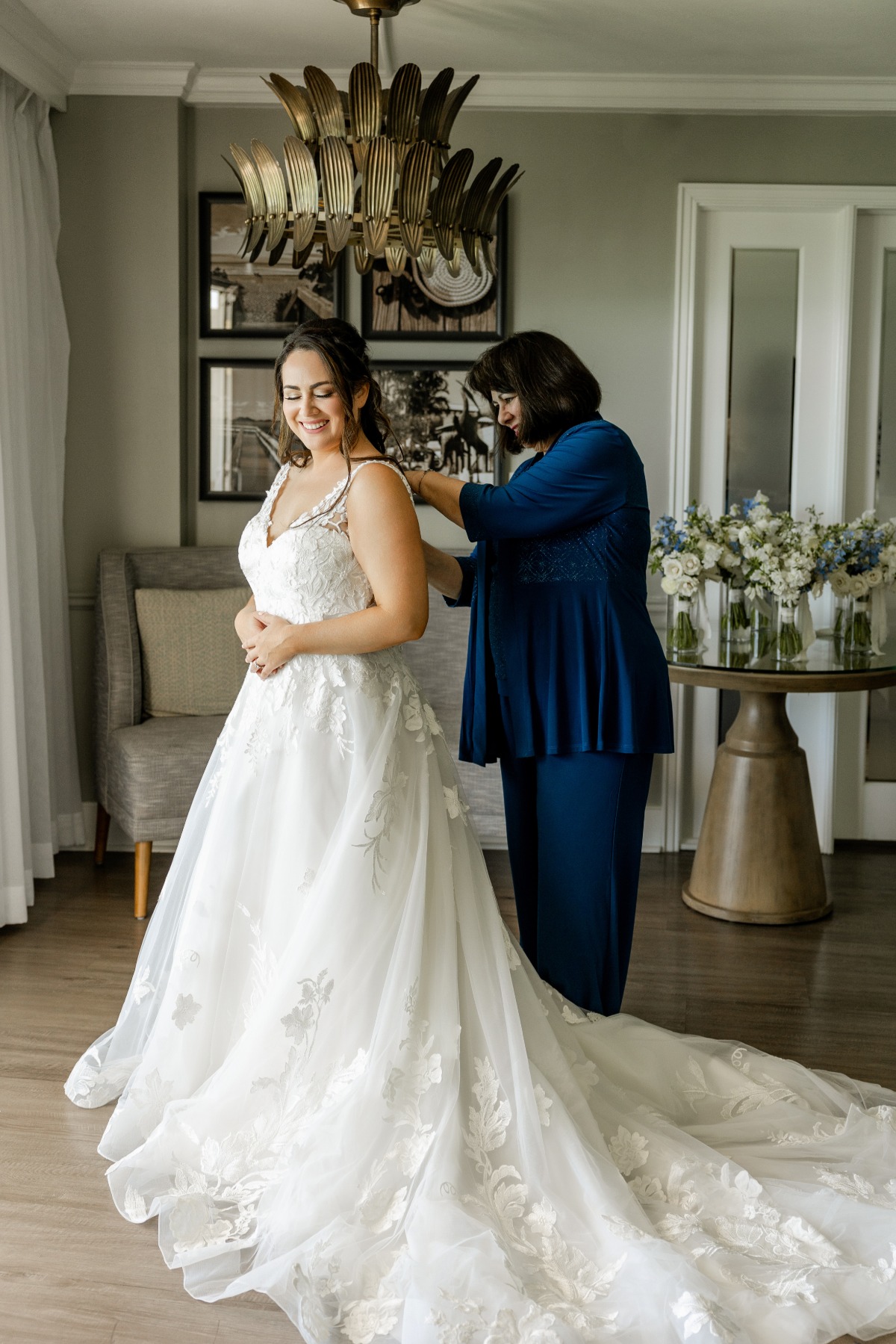 mother of the bride in blue pantsuit and bride in lace gown