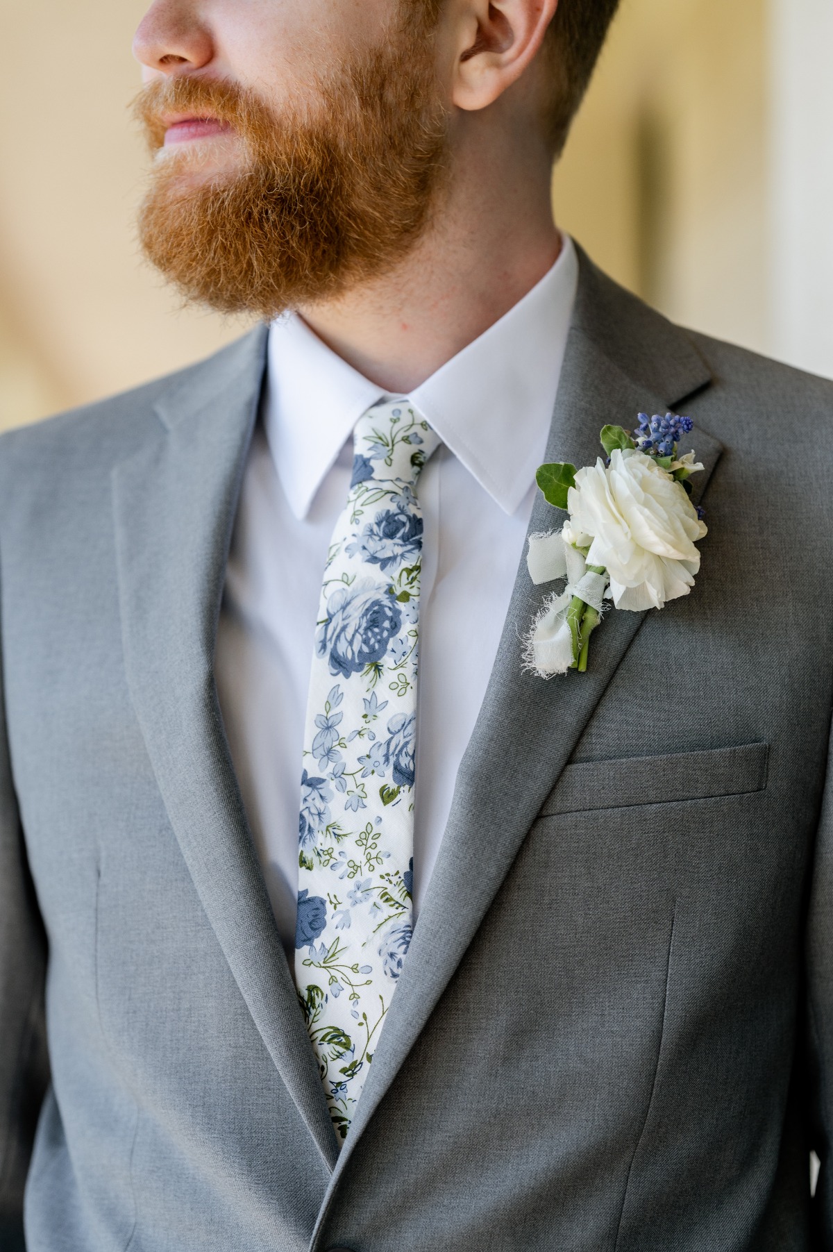 groom wears blue and white floral tie for wedding