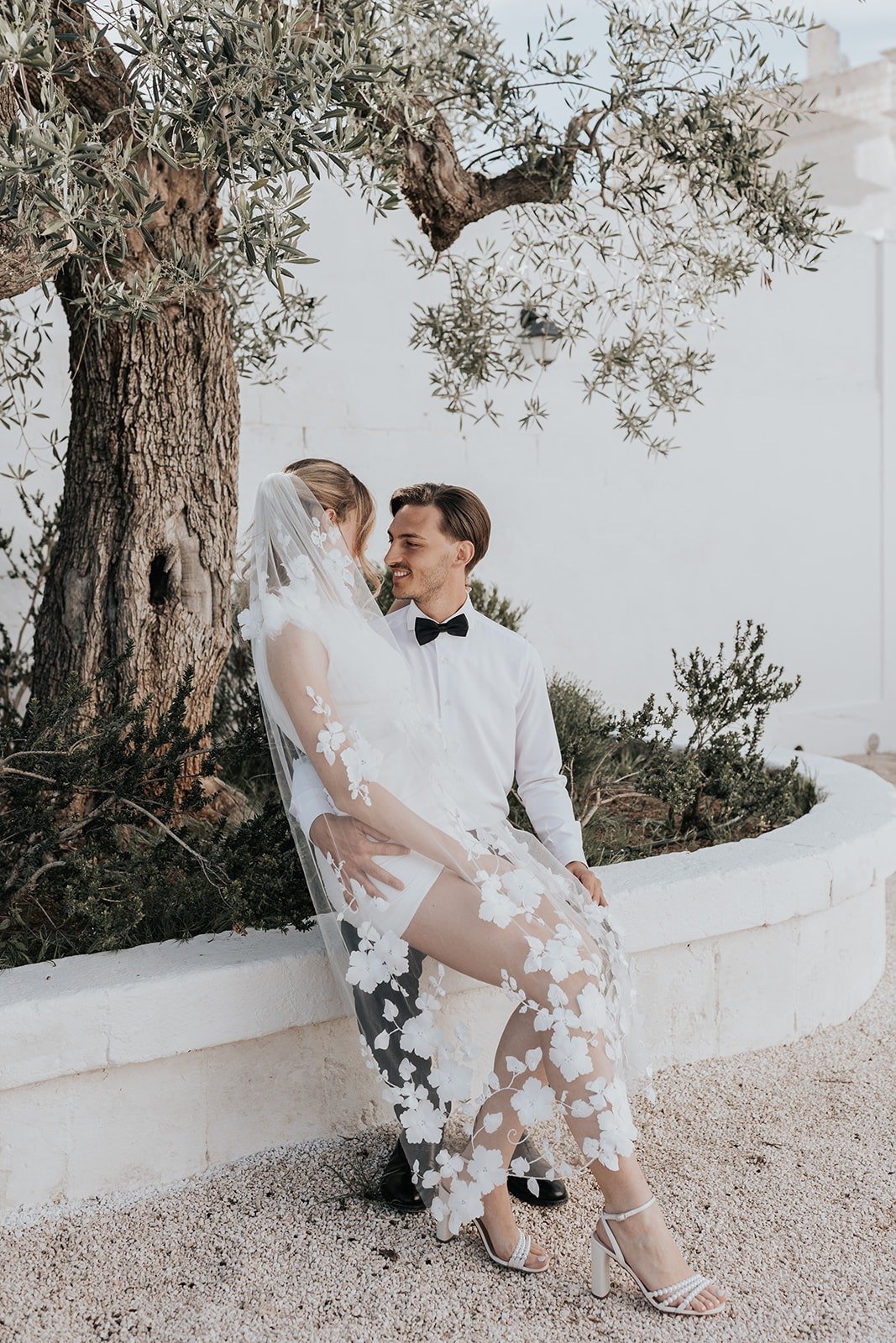 bride in white mini dress with floral veil