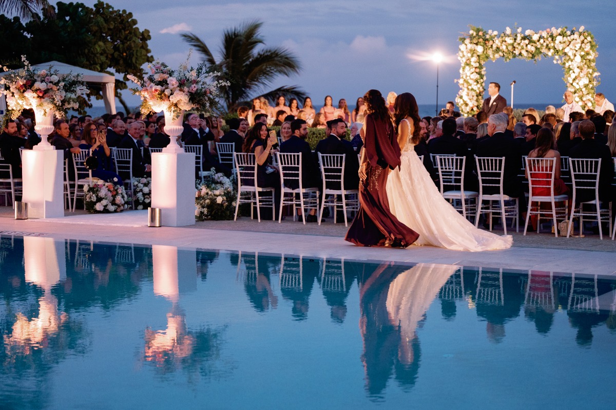 bride walking down the aisle by pool