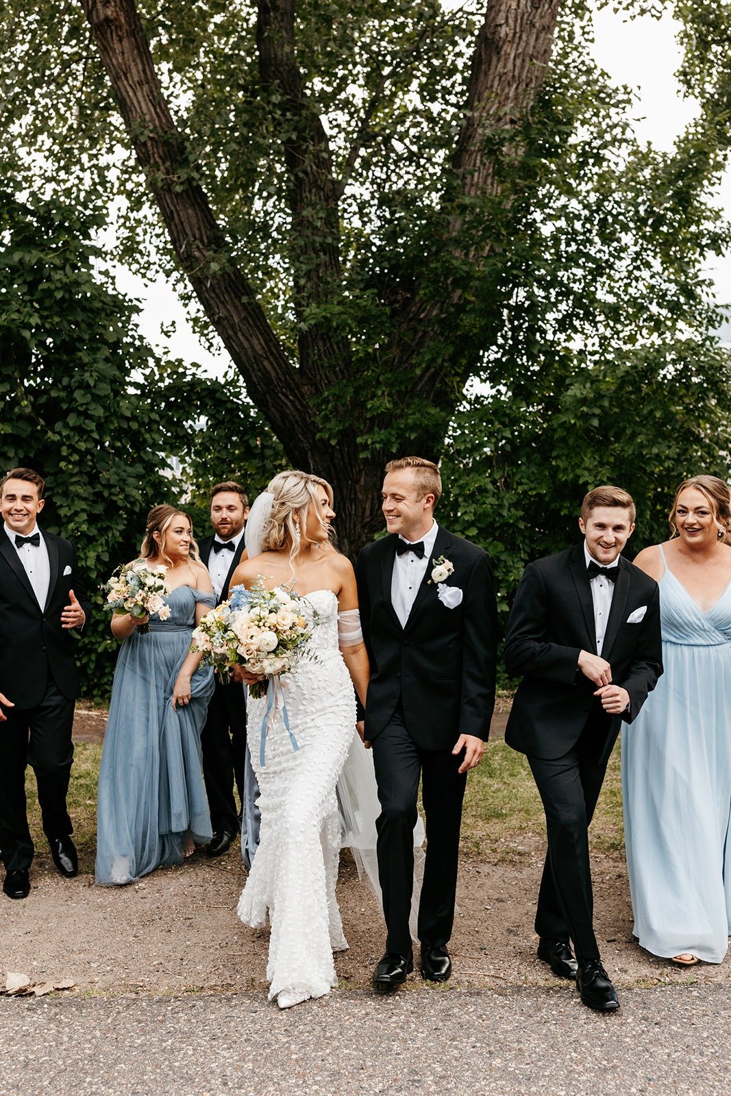 bride and groom with bridesmaids in blue