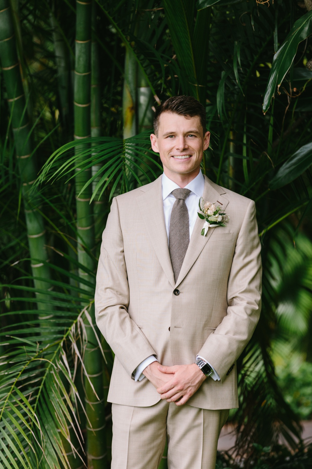 groom in tan suit with brown tie