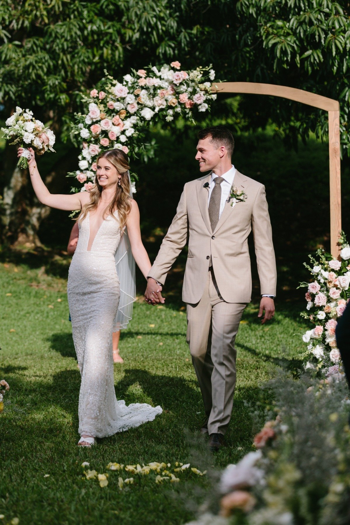 bride and groom at tropical wedding ceremony with pastel florals