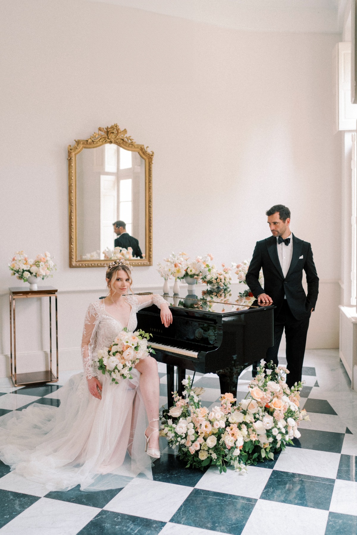 bride and groom with black grand piano in a chateau