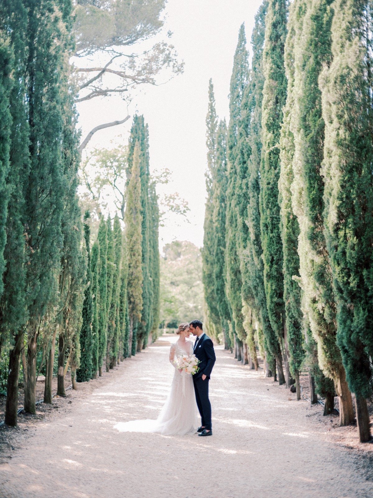 bride and groom pose in garden in provence france