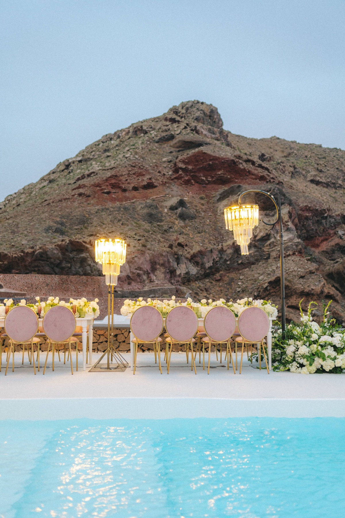 santorini wedding inspiration with chandeliers and pink chairs