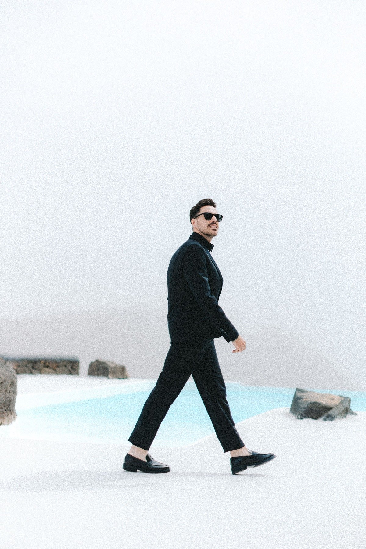 groom in black suit with black shirt and black loafers