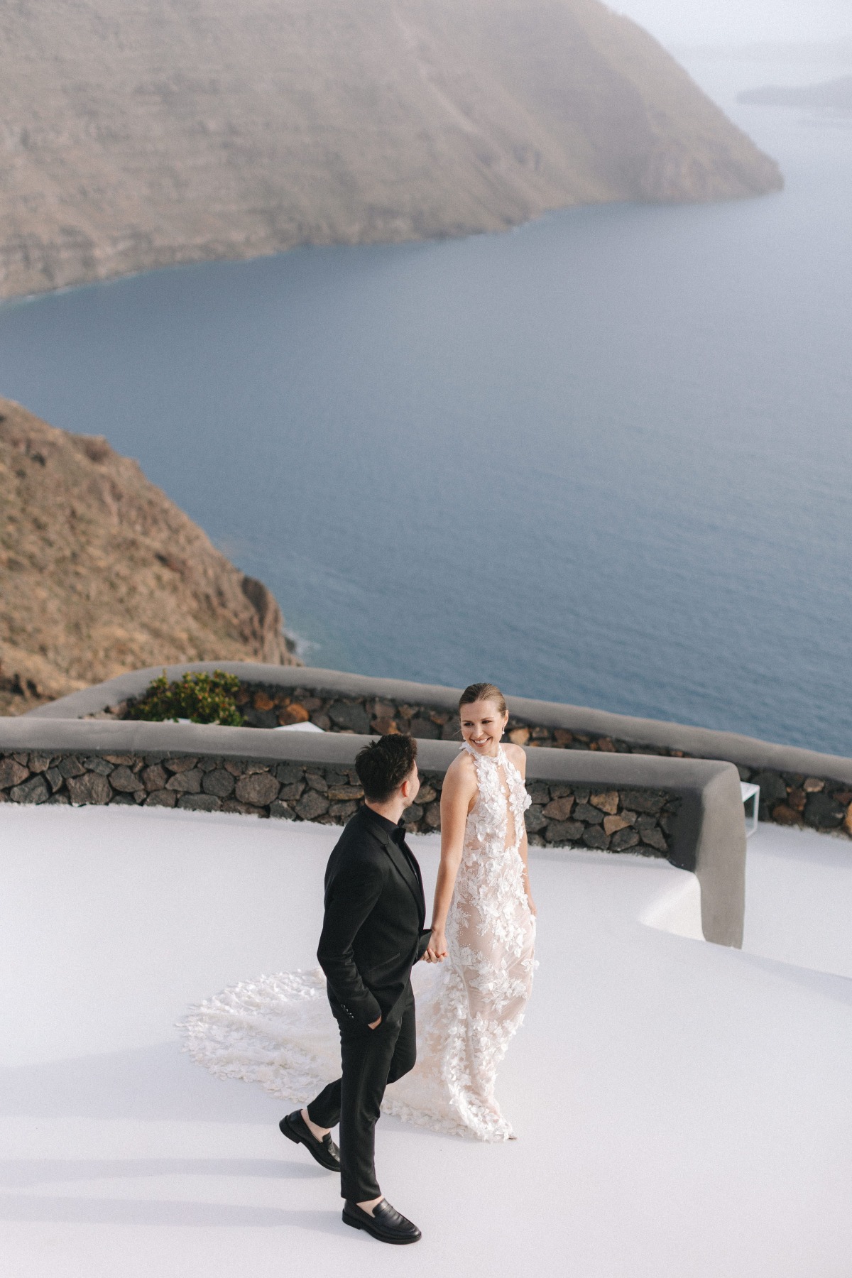 bride and groom at cliffside wedding in santorini greece