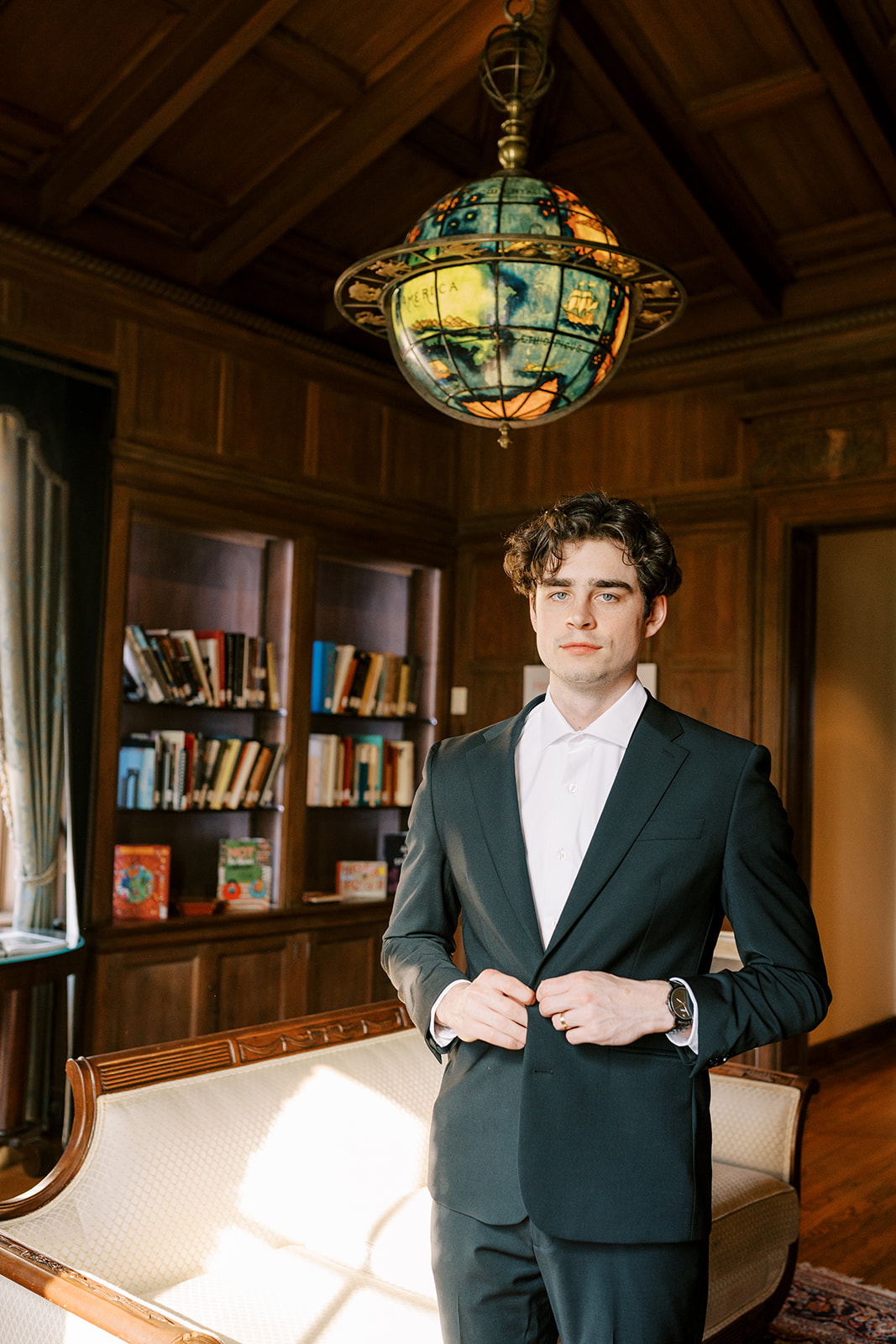 groom getting ready in a wood paneled library