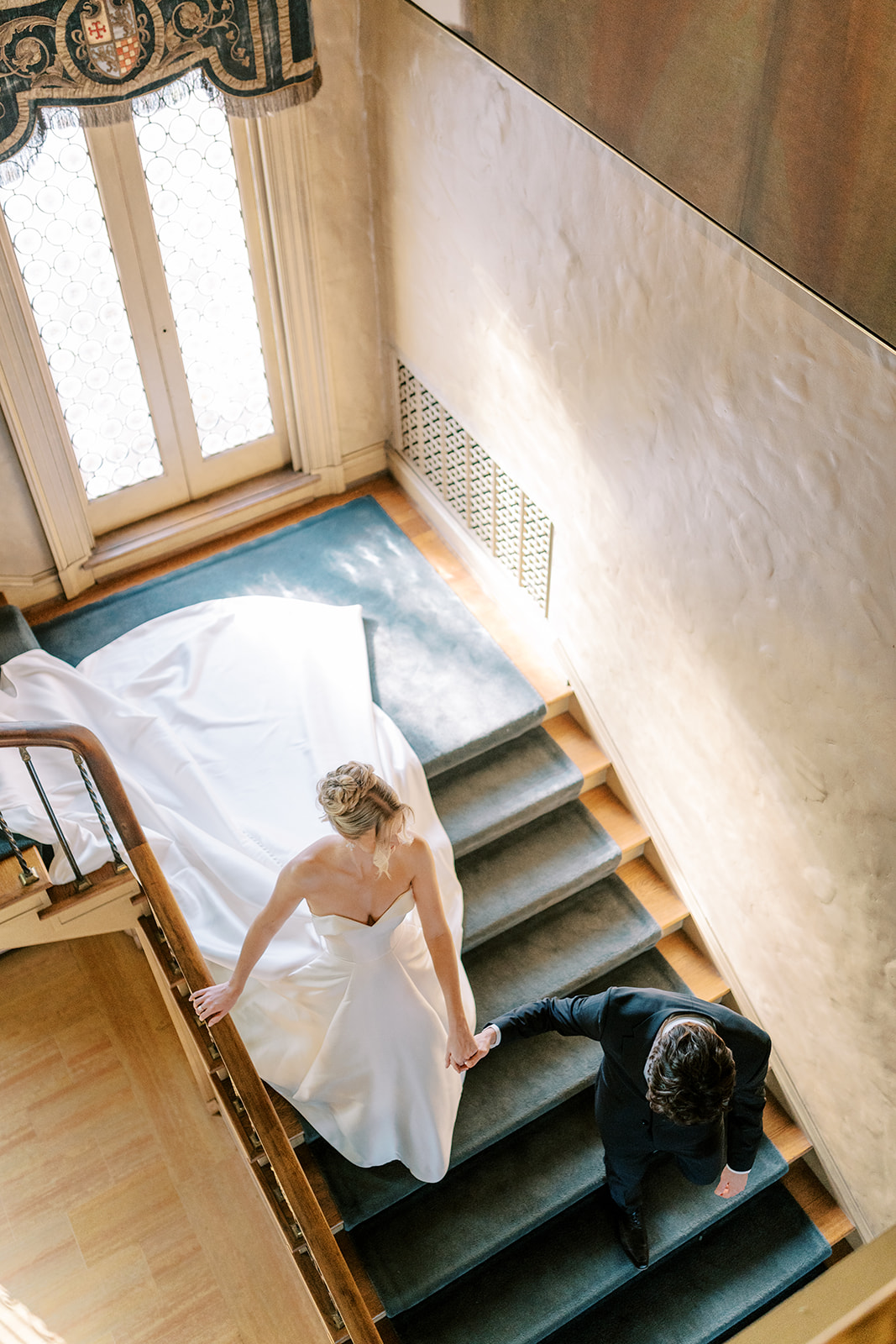 bride and groom walking down blue velvet stairs