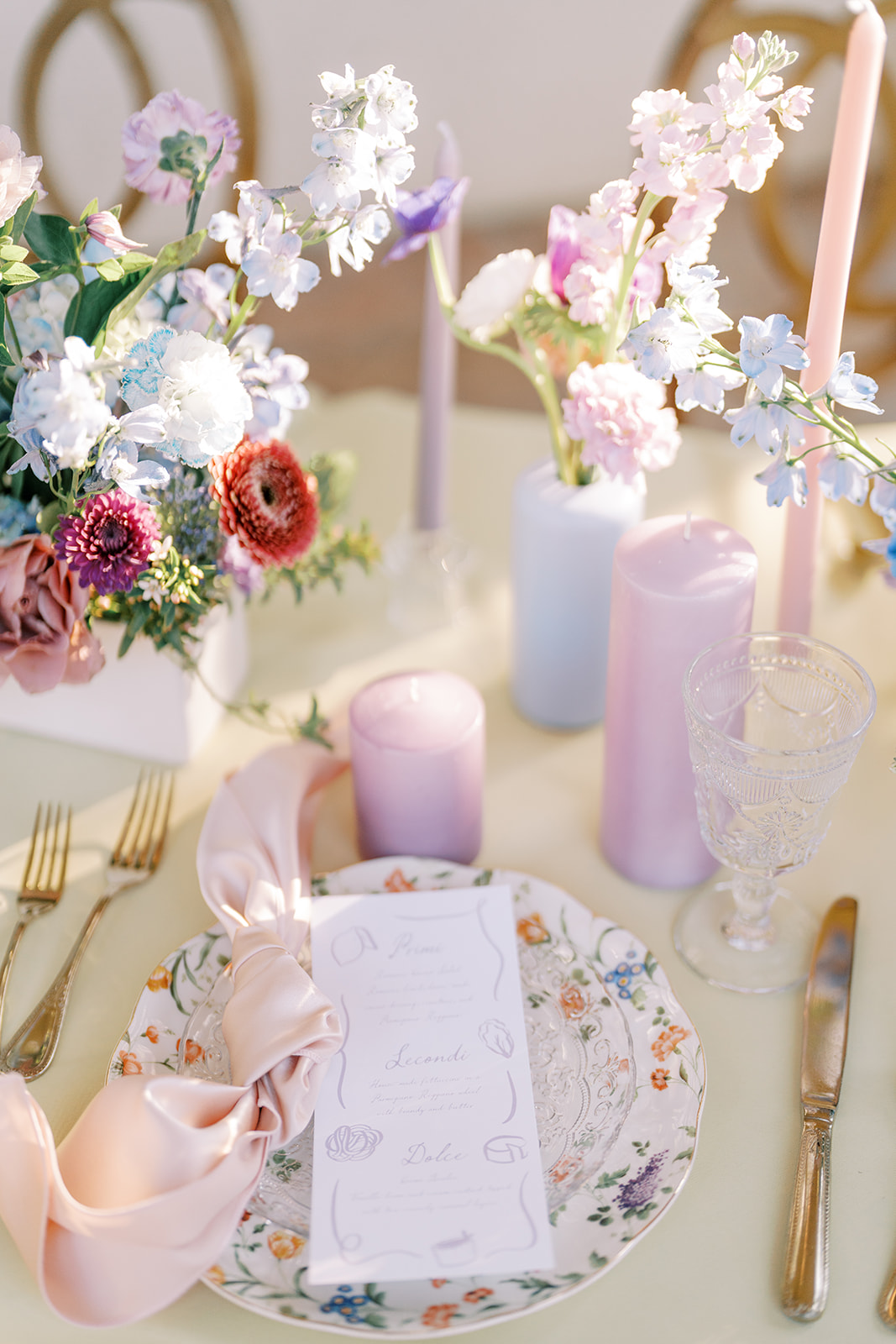 pink and purple candles and pastel floral arrangements for wedding