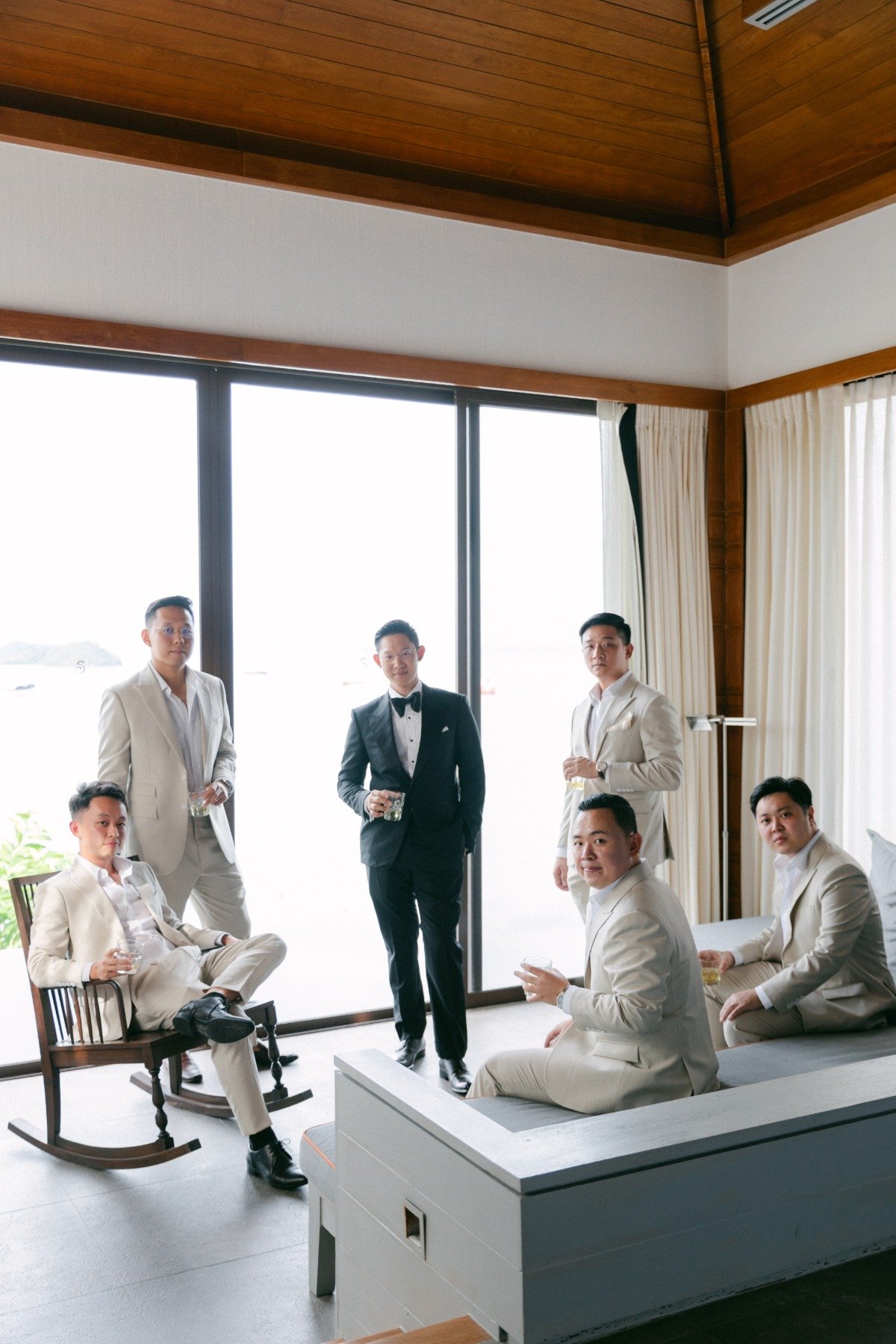 groom in tuxedo with groomsmen in tan suits