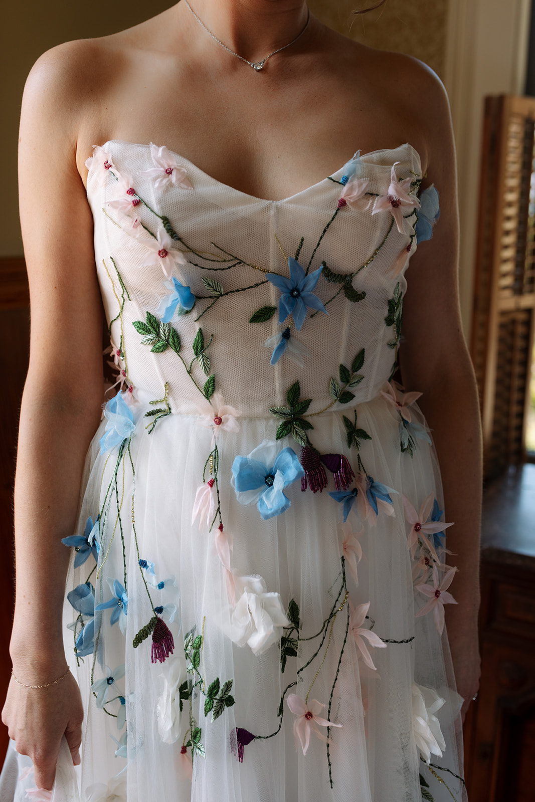 bride in tulle wedding gown with blue and pink flowers