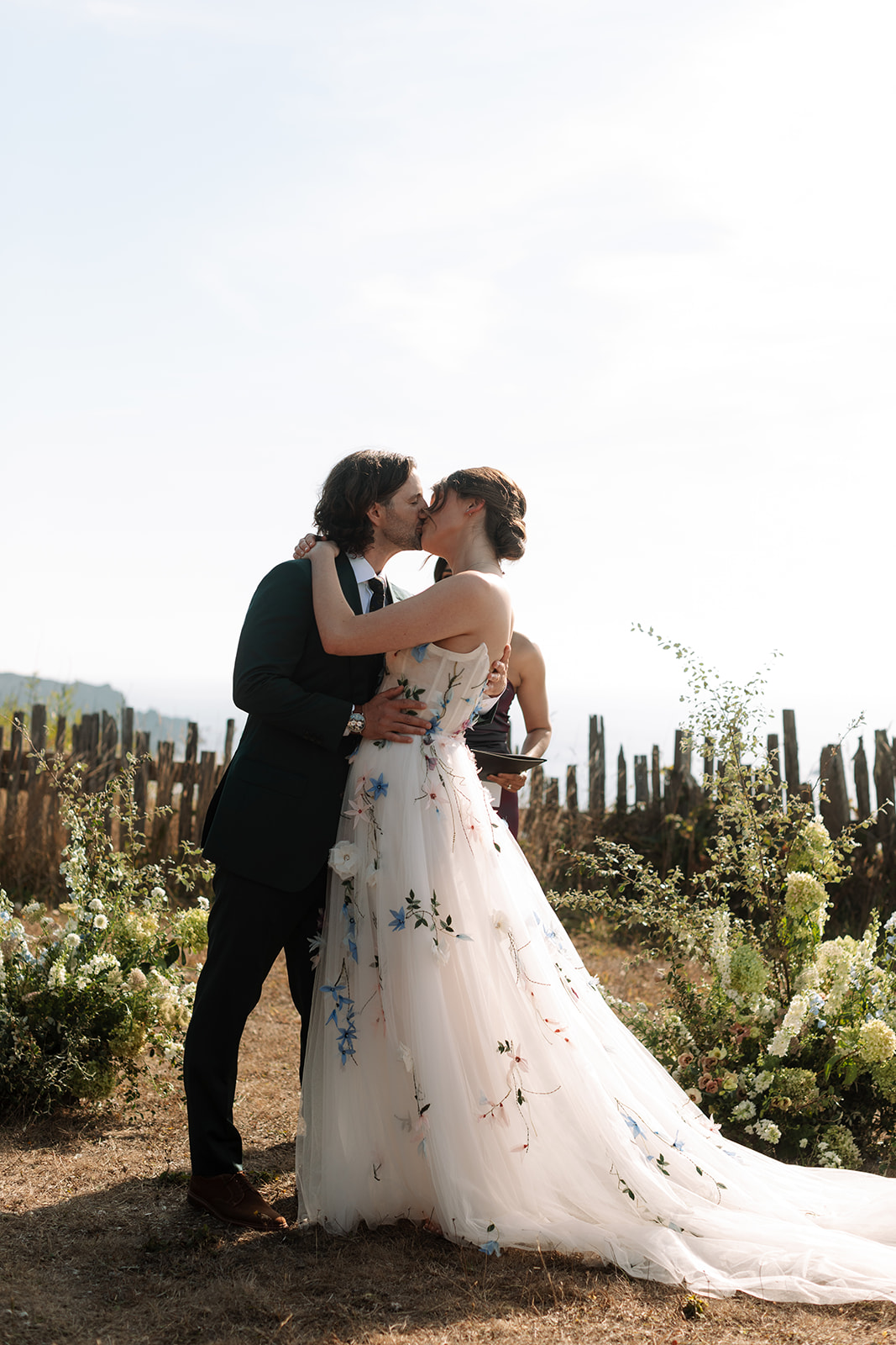 bride and groom kiss at coastal wedding ceremony