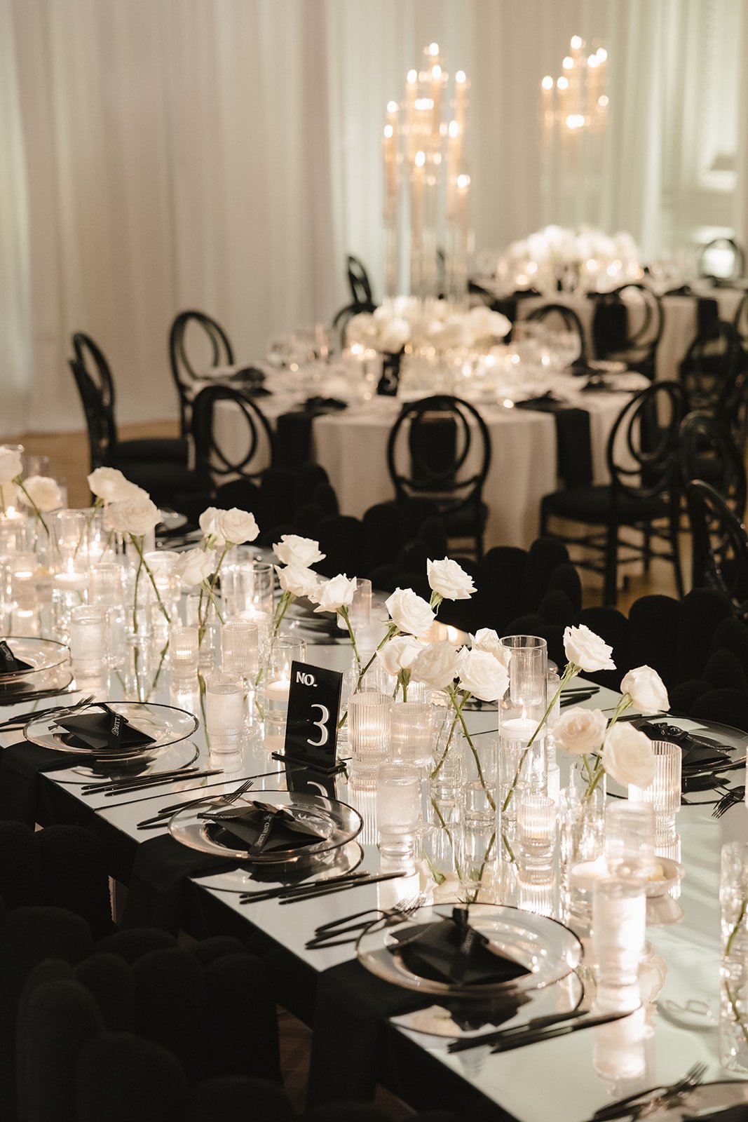 black tables with single stem white roses