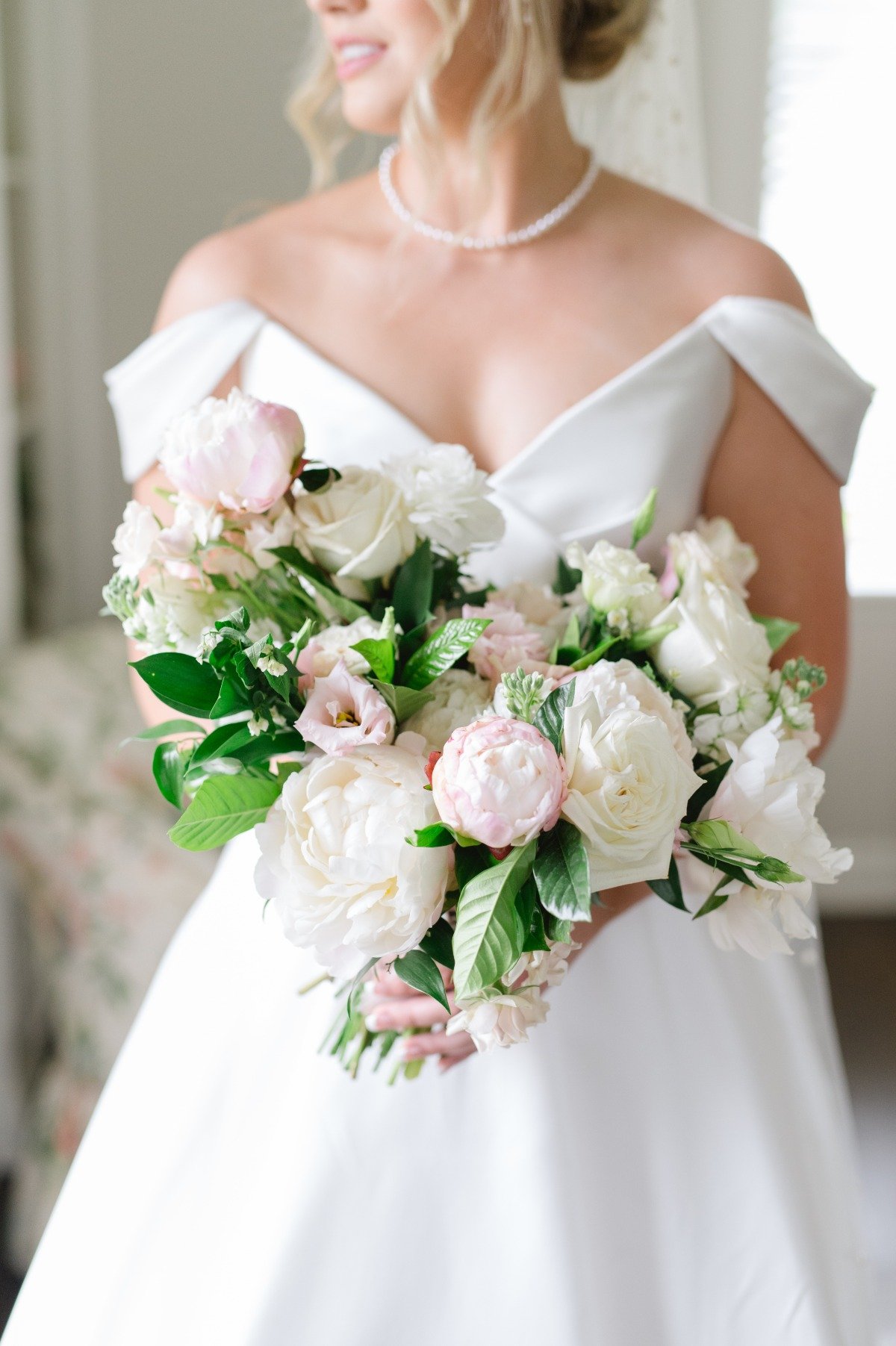 bride with plunging off the shoulder gown and bouquet