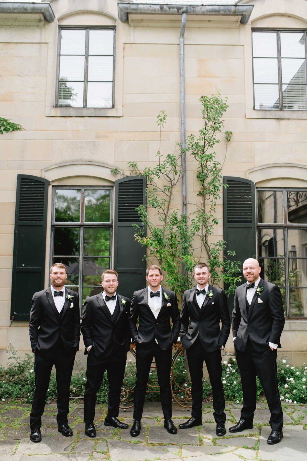 groomsmen in black tuxedos at estate wedding