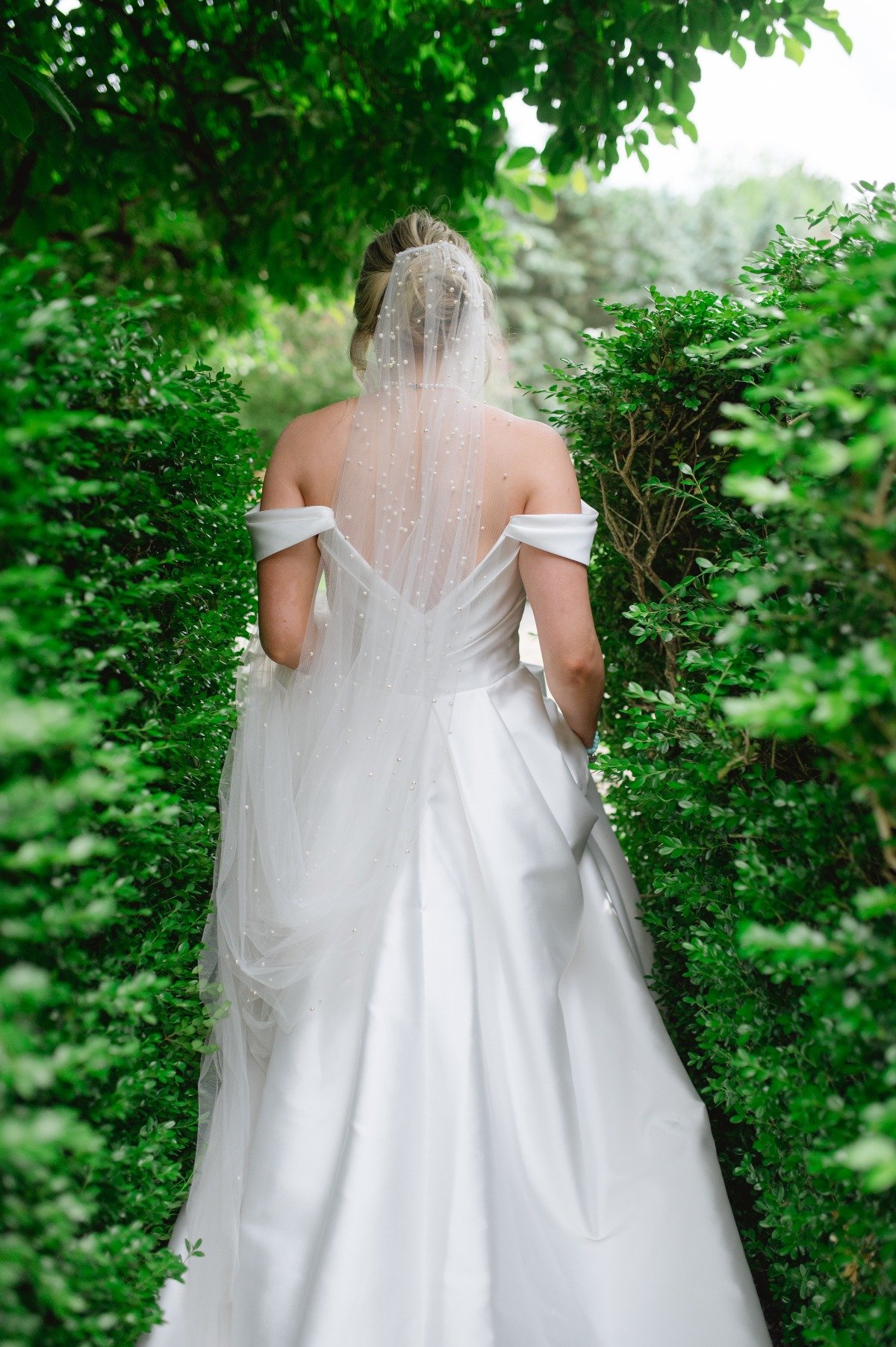 bride with pearl veil walking through garden