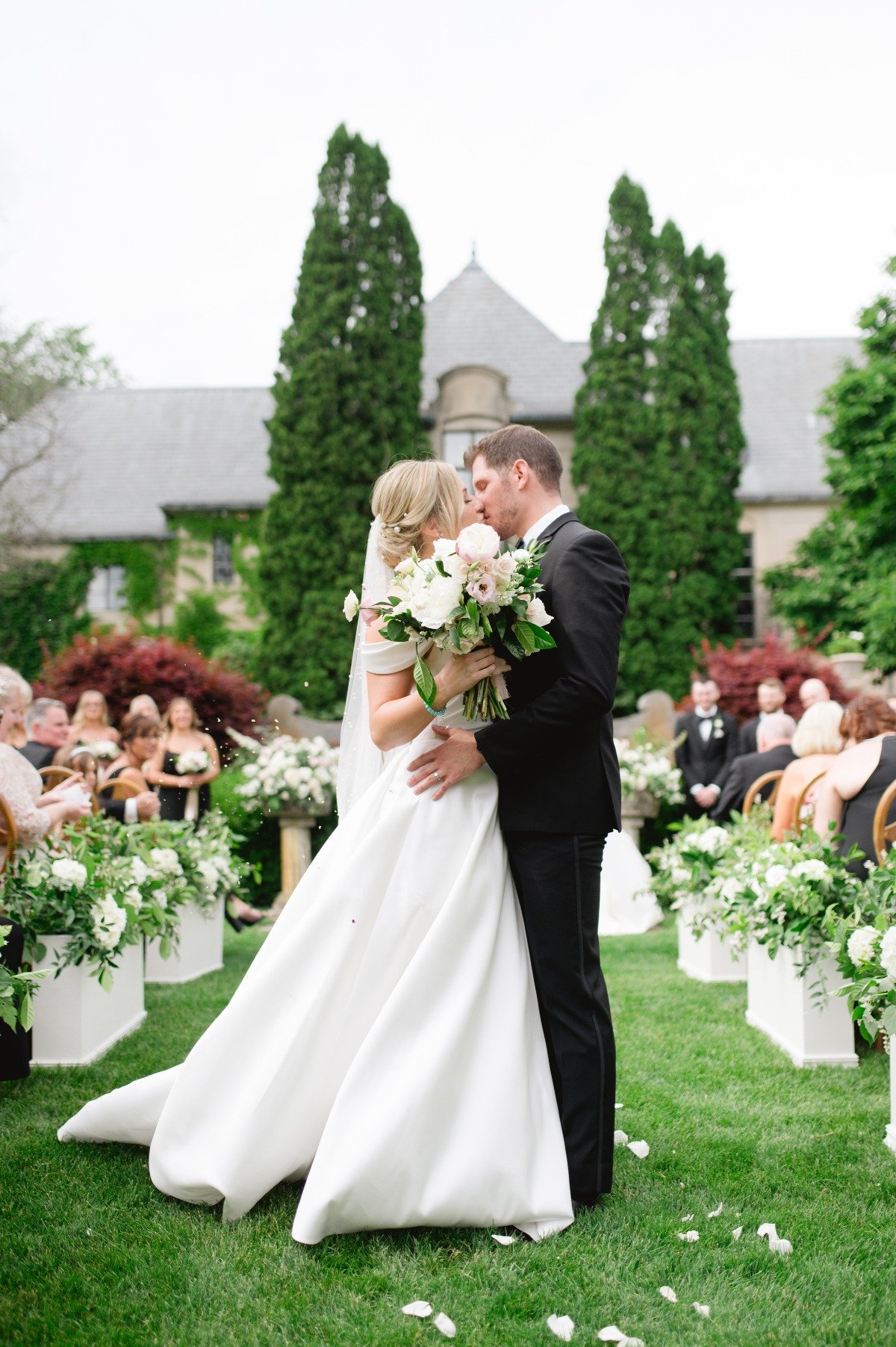 bride and groom kiss at estate garden wedding ceremony