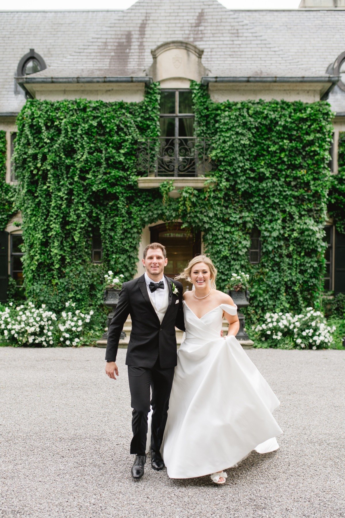 bride and groom in front of manor with vines in michigan