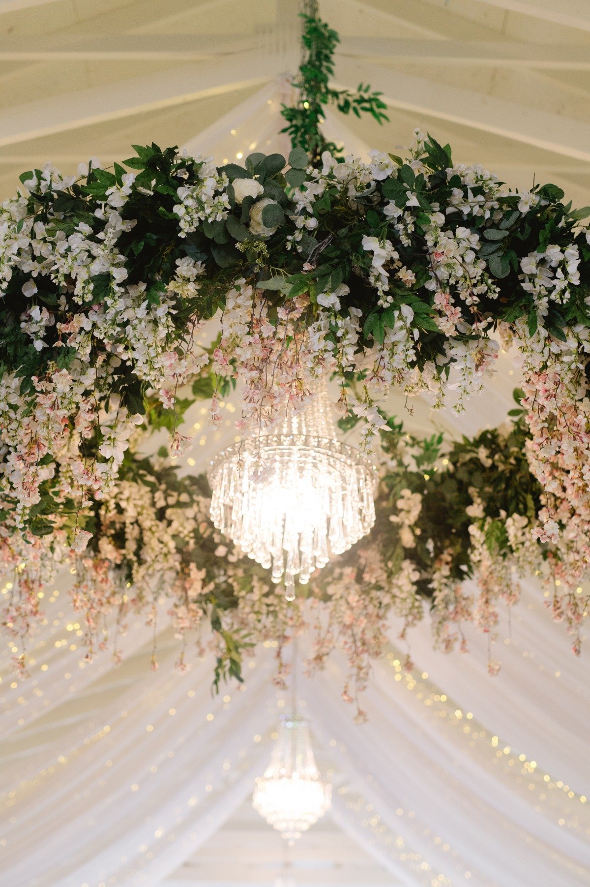 floral chandelier installation at tented wedding reception