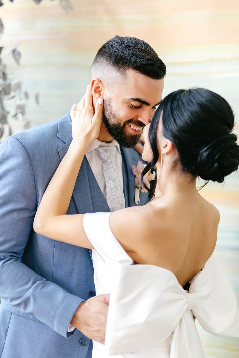 groom in blue suit and bride with a bow on her wedding dress