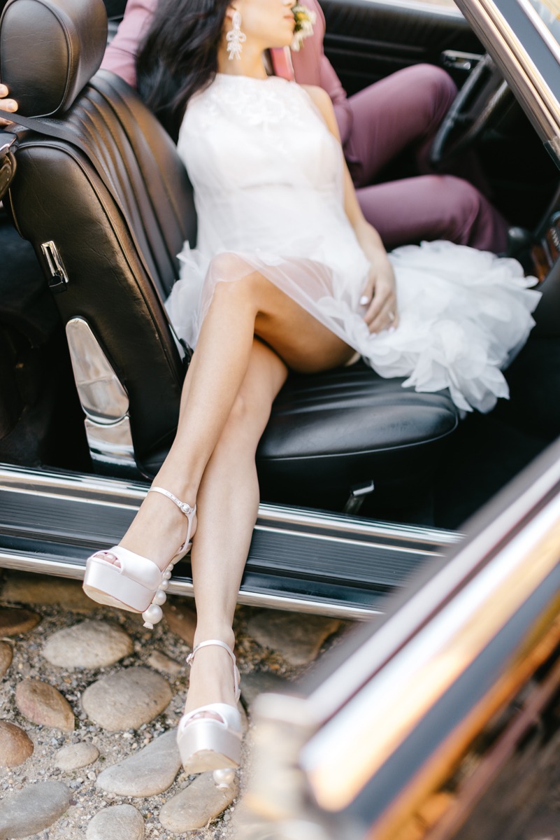 bride and groom exit wedding in vintage car