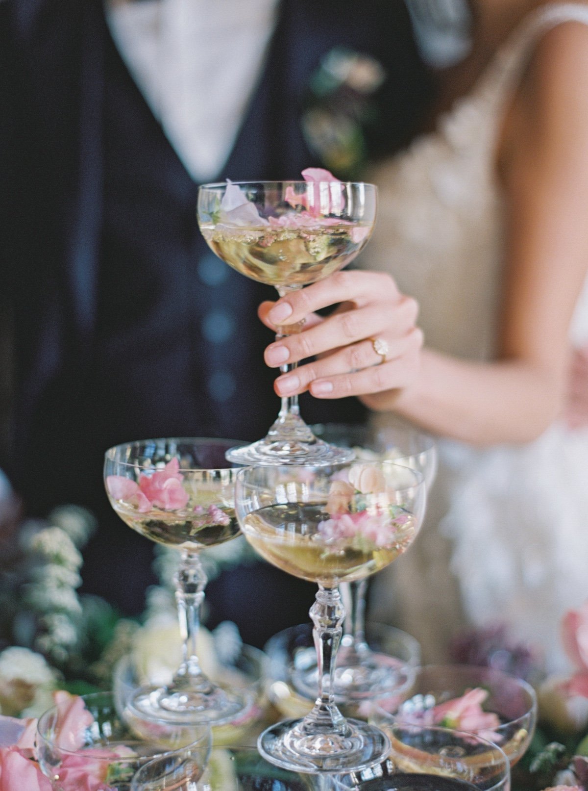 champagne tower with flower petals at a wedding