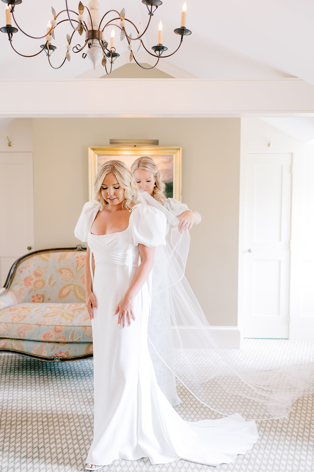 bridesmaid helping bride into dress