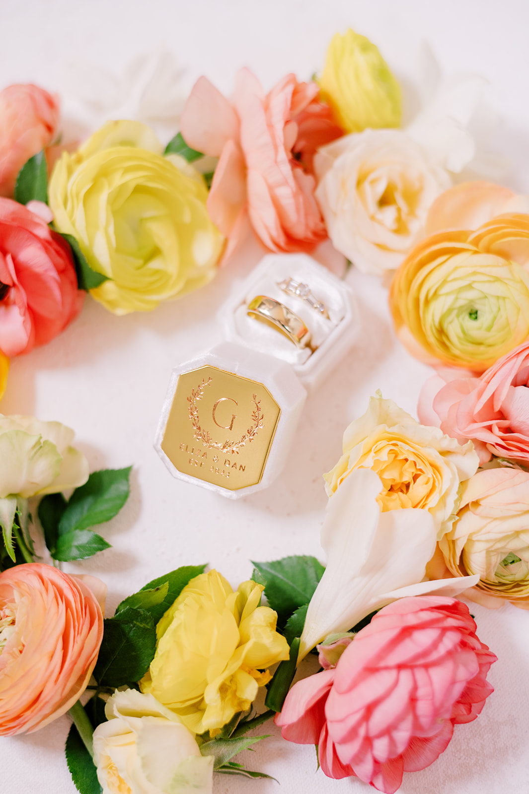 wedding rings with citrus colored flowers