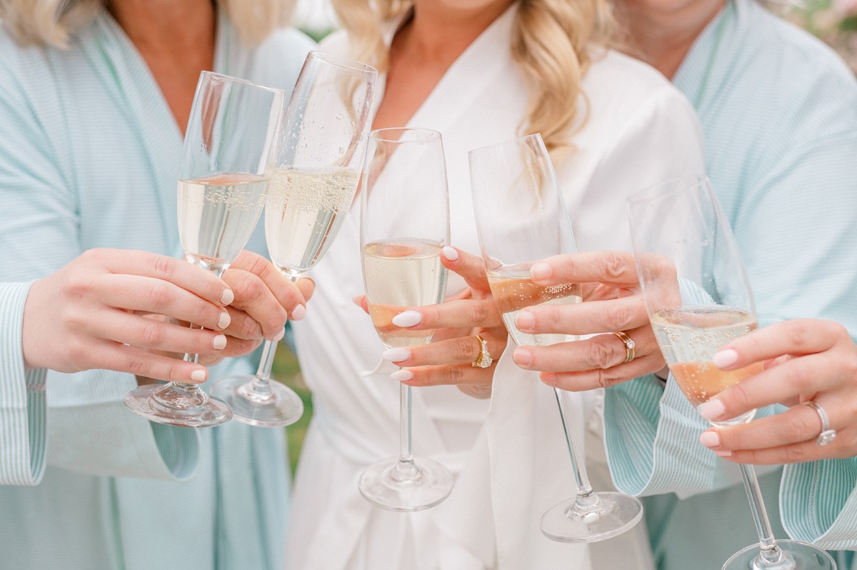 bride and bridesmaids cheers while getting ready