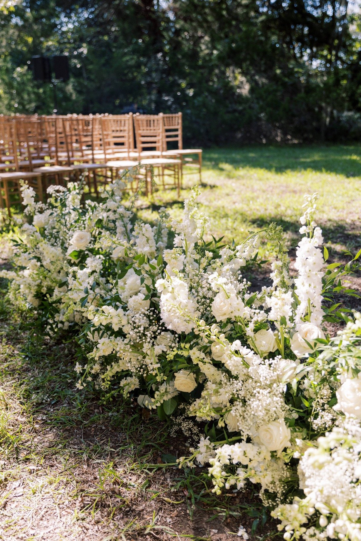 white flower lined aisle at outdoor wedding ceremony