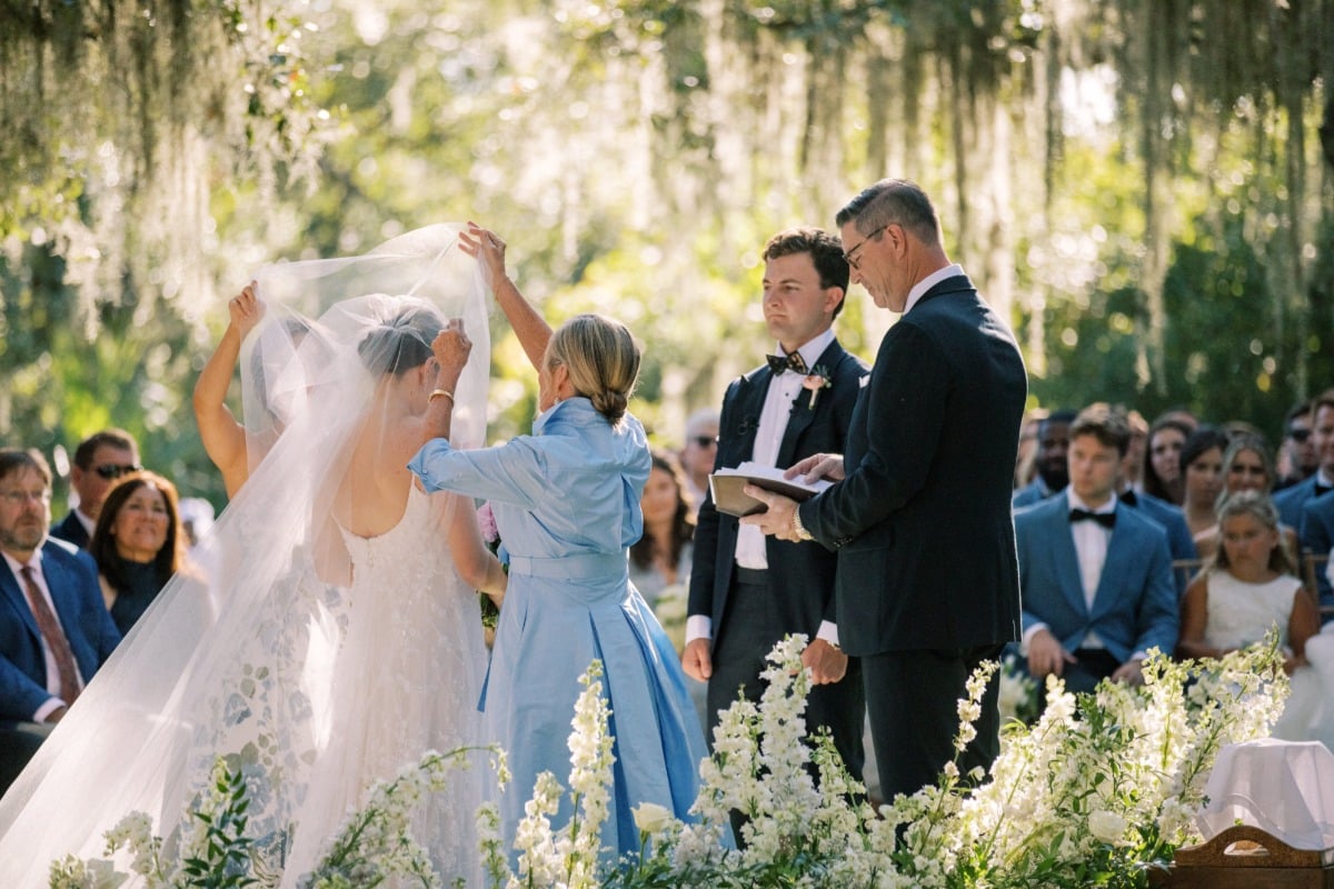 mom helps bride lift blusher at wedding