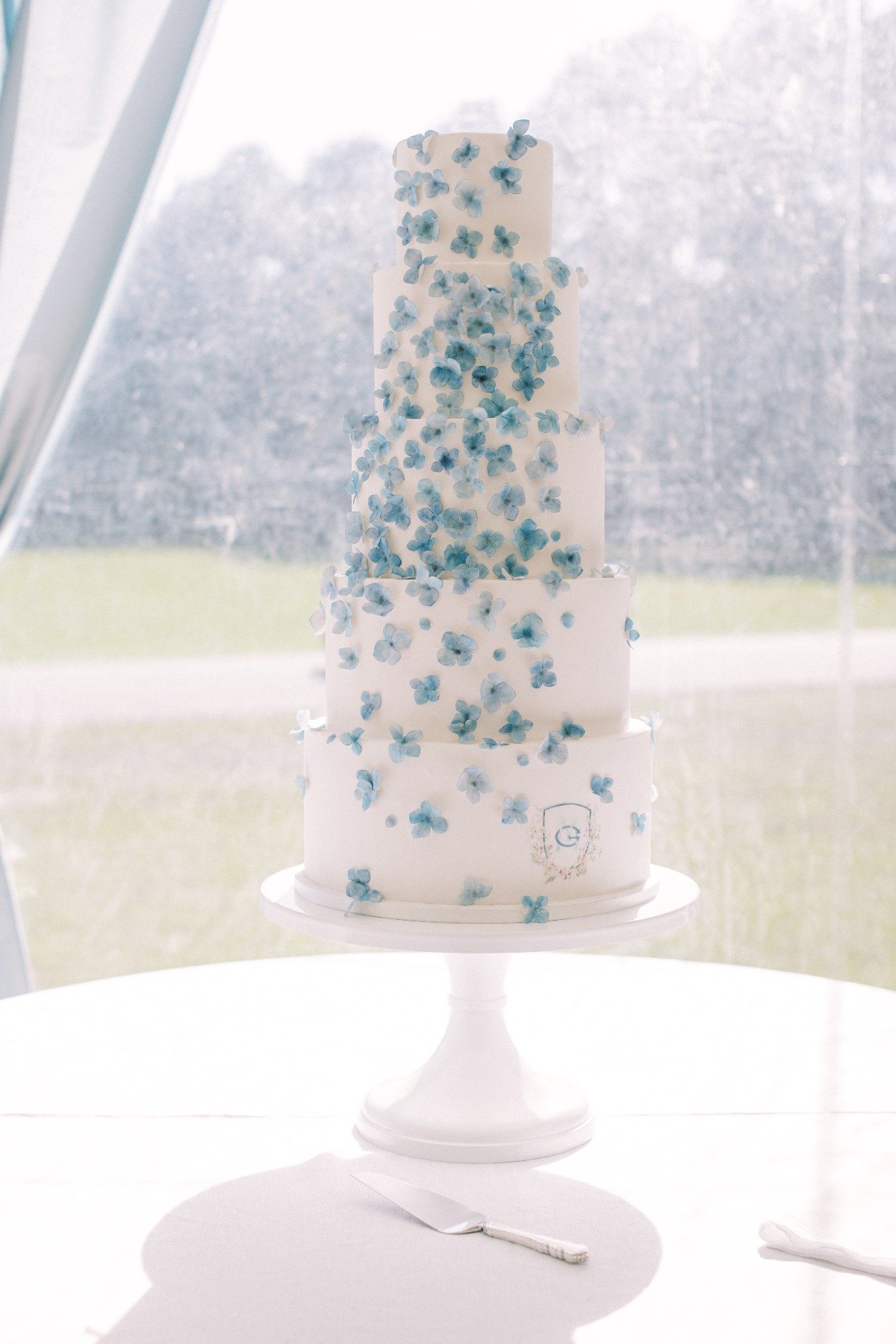 tall wedding cake with blue sugar flowers